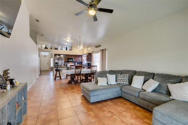 living area with light tile patterned flooring, ceiling fan, visible vents, and lofted ceiling