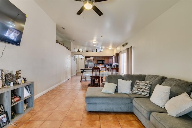 living room with baseboards, ceiling fan, light tile patterned flooring, and lofted ceiling