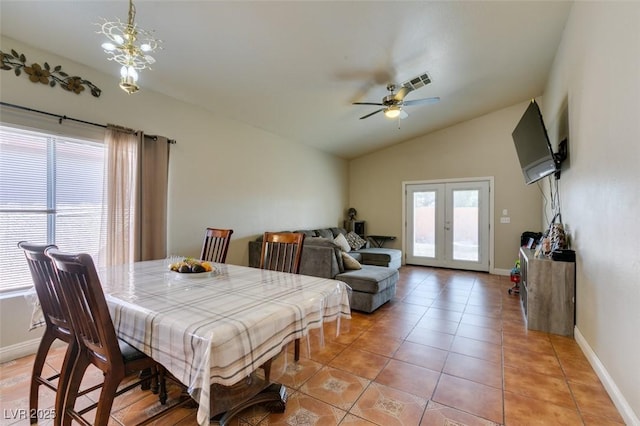 dining space with a ceiling fan, baseboards, visible vents, and lofted ceiling