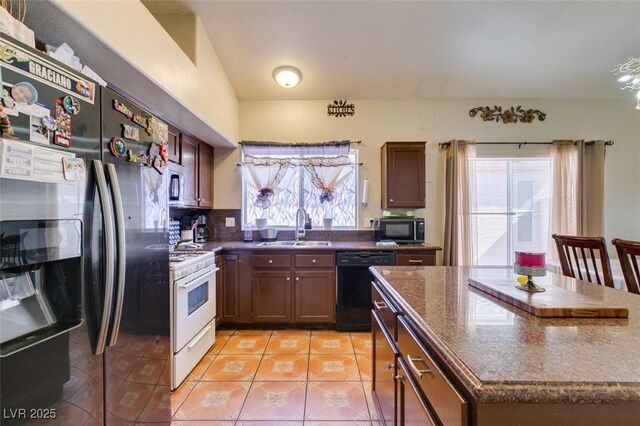 kitchen featuring plenty of natural light, a sink, light tile patterned flooring, and stainless steel appliances