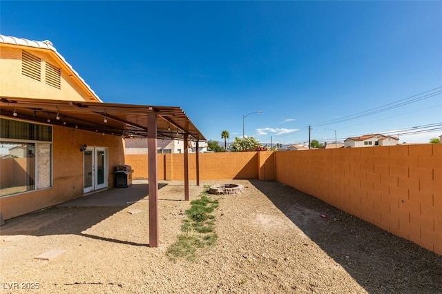 view of yard with french doors and a fenced backyard