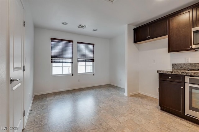 345 Gracious Way, Henderson, NV 89011 - kitchen featuring stainless steel appliances, dark brown cabinetry, baseboards, recessed lighting, and dark stone countertops
