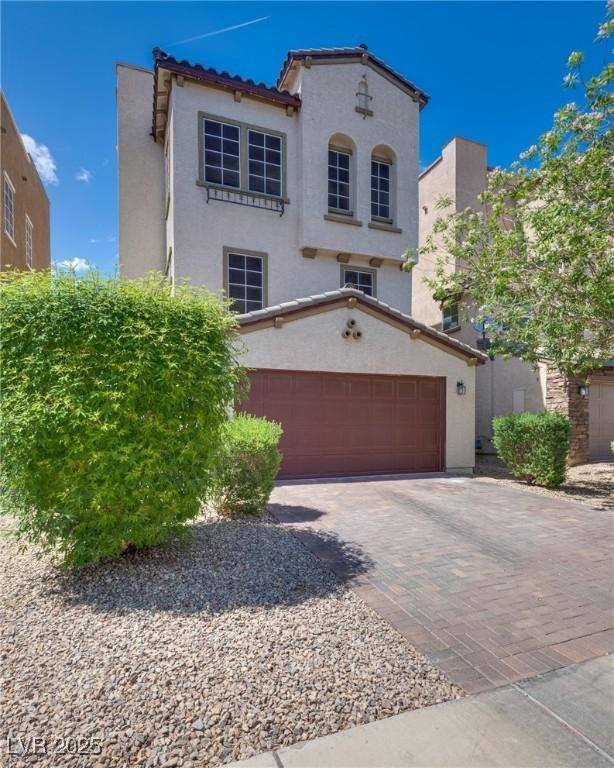 345 Gracious Way, Henderson, NV 89011 - mediterranean / spanish-style home with stucco siding, a garage, driveway, and a tile roof