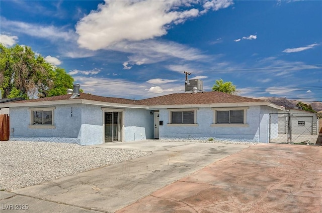 view of front of home with fence, a gate, and stucco siding