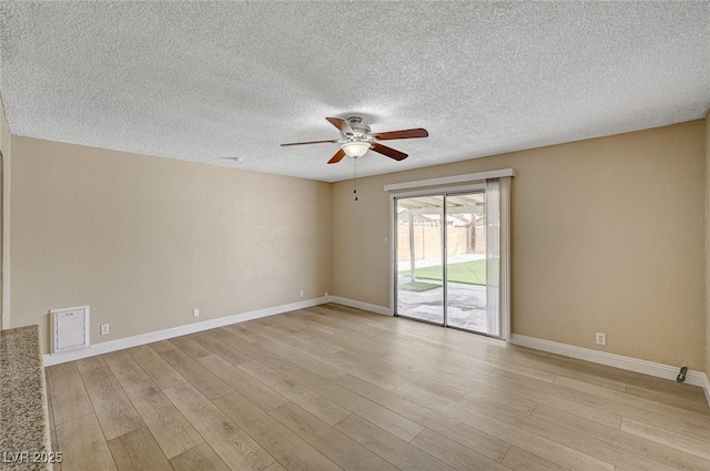 empty room with a ceiling fan, a textured ceiling, baseboards, and light wood-style floors