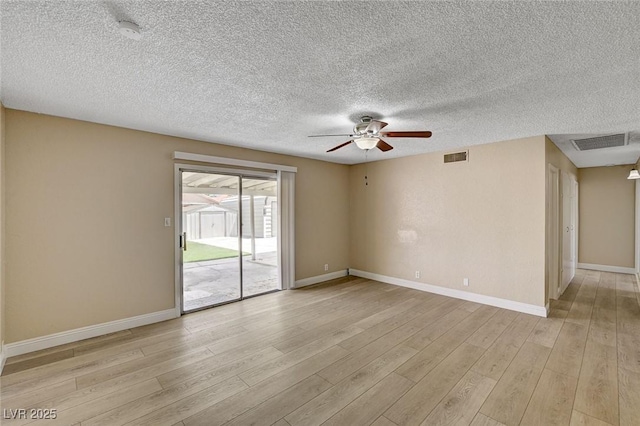 spare room featuring visible vents, light wood-style floors, baseboards, a textured ceiling, and a ceiling fan