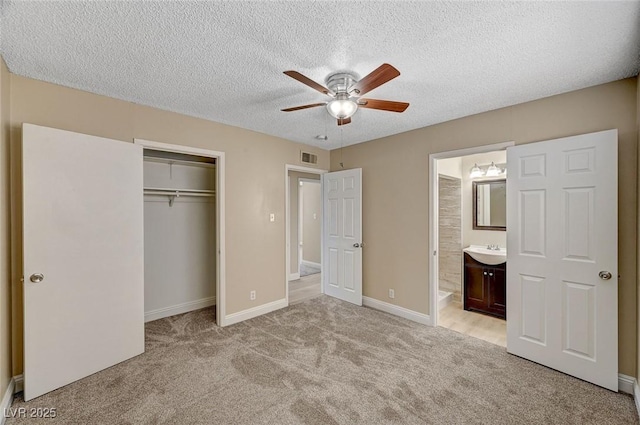 unfurnished bedroom with a textured ceiling, visible vents, light carpet, and a closet