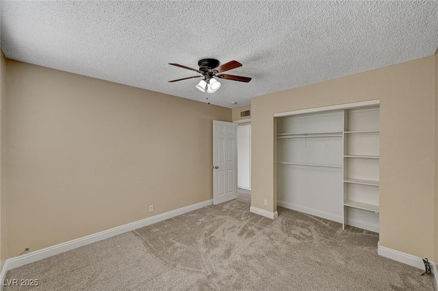 unfurnished bedroom featuring a textured ceiling, visible vents, carpet floors, baseboards, and a closet