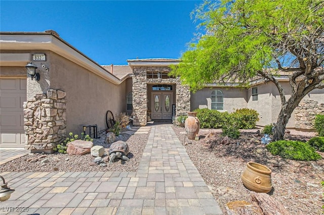 entrance to property with a tiled roof, stone siding, and stucco siding