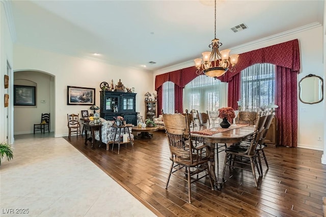 dining room with an inviting chandelier, arched walkways, crown molding, and visible vents