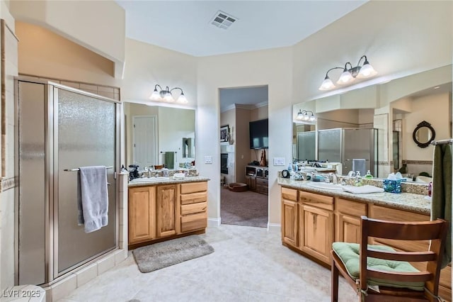 full bath with a sink, tile patterned flooring, two vanities, a shower stall, and visible vents
