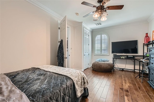 bedroom with visible vents, ornamental molding, wood finished floors, baseboards, and ceiling fan
