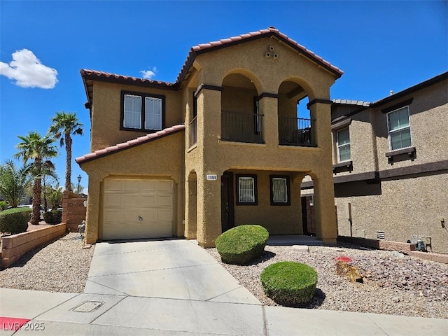 mediterranean / spanish home featuring an attached garage, stucco siding, concrete driveway, a balcony, and a tiled roof