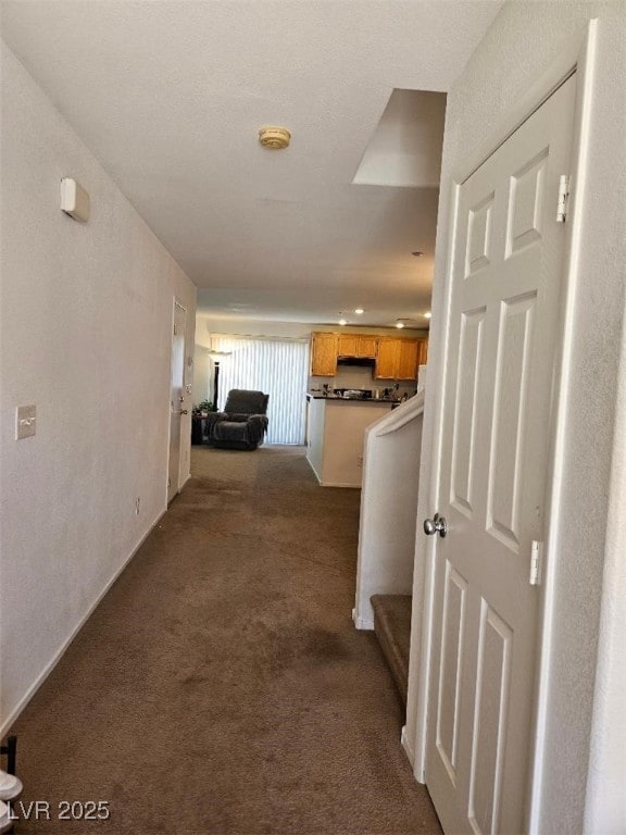 corridor with dark colored carpet