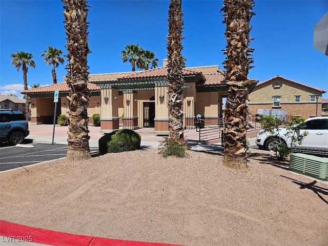 view of front of home featuring uncovered parking, stucco siding, and a tile roof