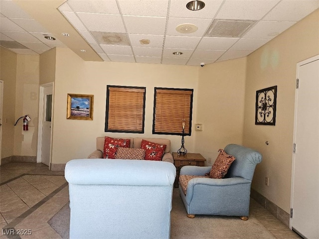 sitting room featuring baseboards, visible vents, and a drop ceiling