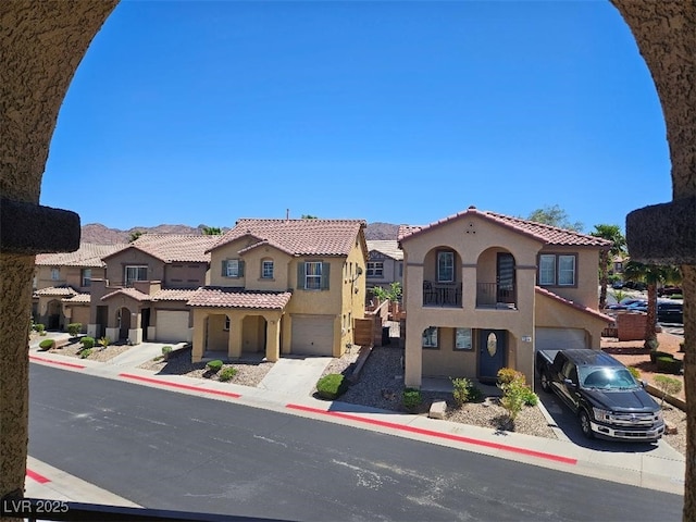 view of front facade with a residential view, an attached garage, concrete driveway, and stucco siding