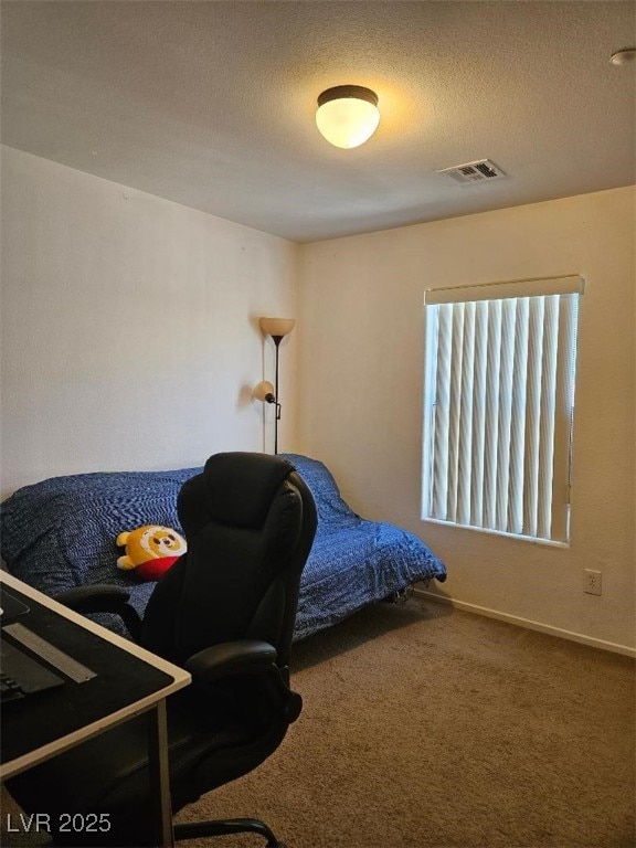 bedroom featuring a textured ceiling, visible vents, and carpet