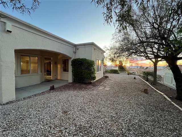 10717 Grand Cypress Ave, Las Vegas, NV 89134 - property exterior at dusk featuring a patio, stucco siding, and fence