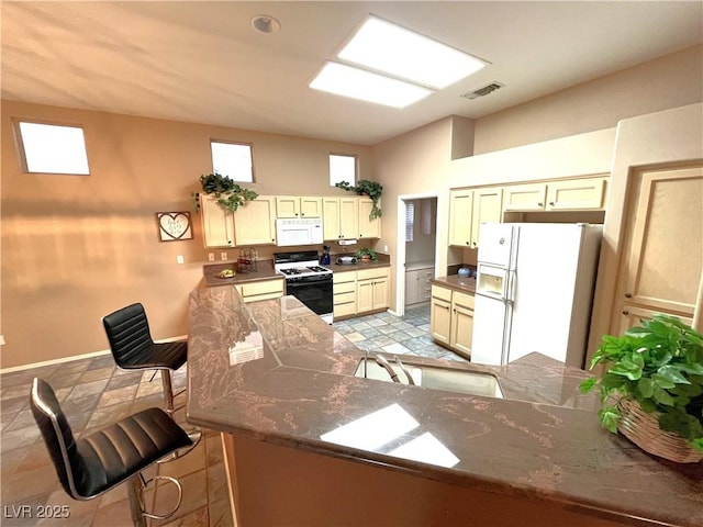 10717 Grand Cypress Ave, Las Vegas, NV 89134 - kitchen with a sink, white appliances, a peninsula, baseboards, and visible vents