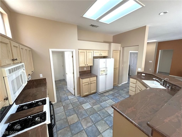 10717 Grand Cypress Ave, Las Vegas, NV 89134 - kitchen with visible vents, a sink, stone finish floor, and white appliances