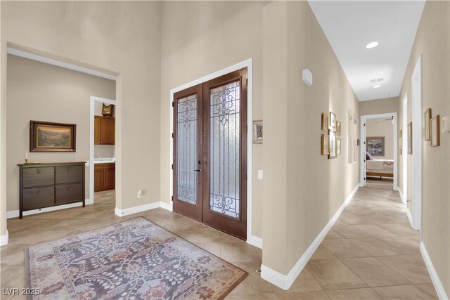 entryway featuring light tile patterned floors, baseboards, and french doors