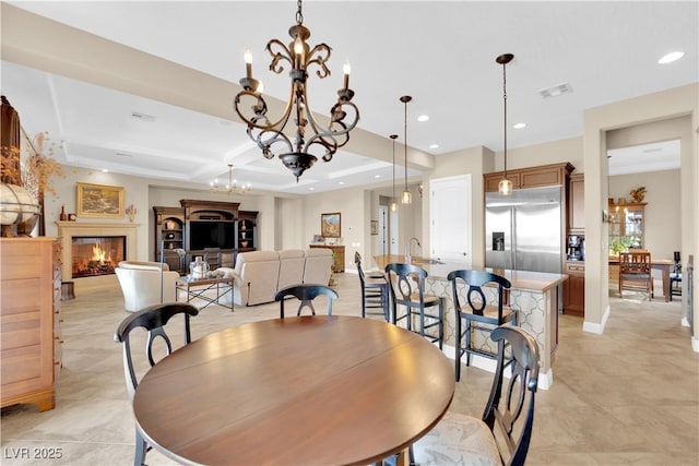 dining room with visible vents, a lit fireplace, recessed lighting, a chandelier, and coffered ceiling