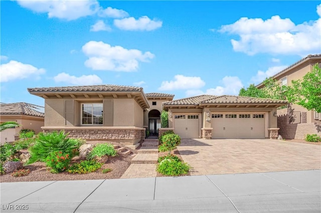 mediterranean / spanish-style home with a garage, stucco siding, driveway, and a tile roof