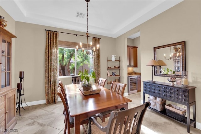 dining space with wine cooler, a raised ceiling, visible vents, and a chandelier