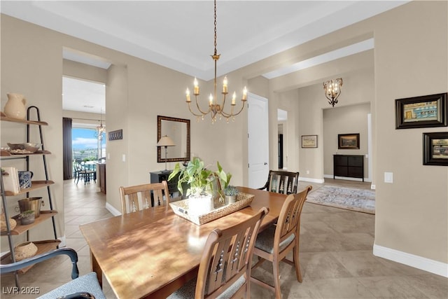 dining space featuring baseboards, light tile patterned floors, and a chandelier