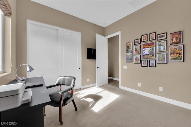 office featuring baseboards and light carpet
