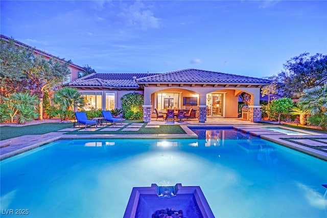 pool with a jacuzzi and a patio area
