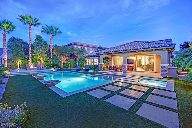 pool featuring an exterior structure, a patio, an in ground hot tub, and an outdoor structure