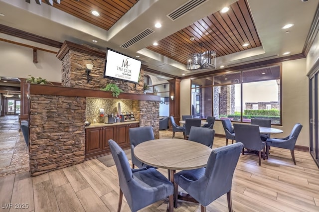 dining room with visible vents, crown molding, light wood-type flooring, wooden ceiling, and a tray ceiling