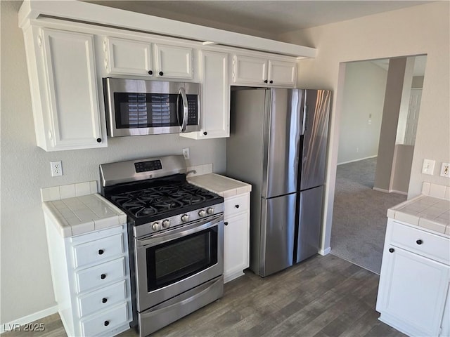734 Rusty Spur Dr, Henderson, NV 89014 - kitchen featuring tile countertops, appliances with stainless steel finishes, baseboards, white cabinetry, and dark wood-type flooring