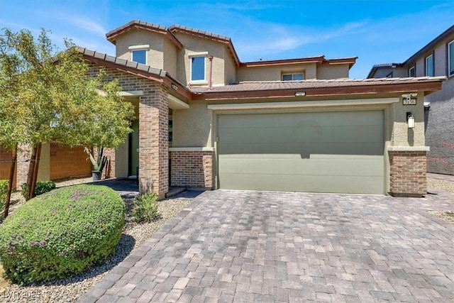 3136 Mossfield Ave, Henderson, NV 89052 - view of front of house featuring stucco siding, decorative driveway, a tile roof, a garage, and brick siding