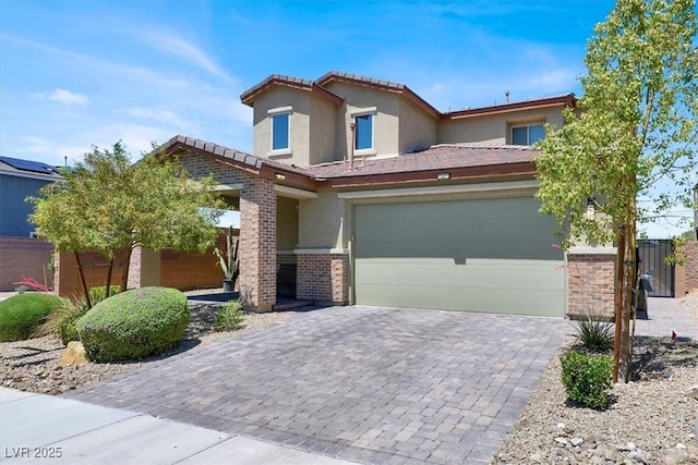 3136 Mossfield Ave, Henderson, NV 89052 - view of front of home with decorative driveway, stucco siding, a tile roof, brick siding, and an attached garage
