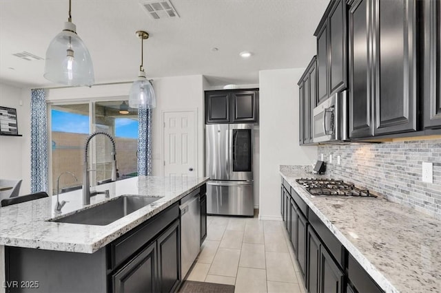 3136 Mossfield Ave, Henderson, NV 89052 - kitchen featuring stainless steel appliances, a kitchen island with sink, decorative backsplash, light stone countertops, and recessed lighting