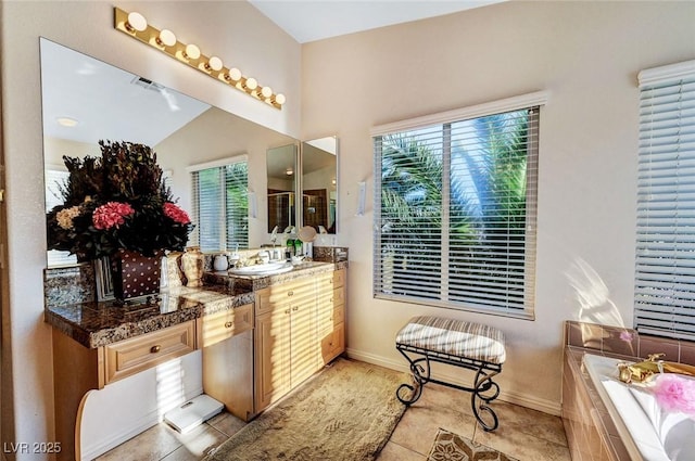 full bath featuring vanity, a bath, baseboards, and tile patterned flooring