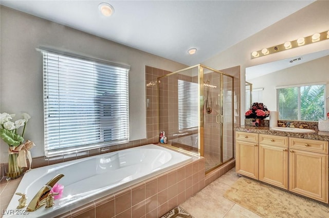 bathroom with a garden tub, a shower stall, tile patterned floors, and vanity