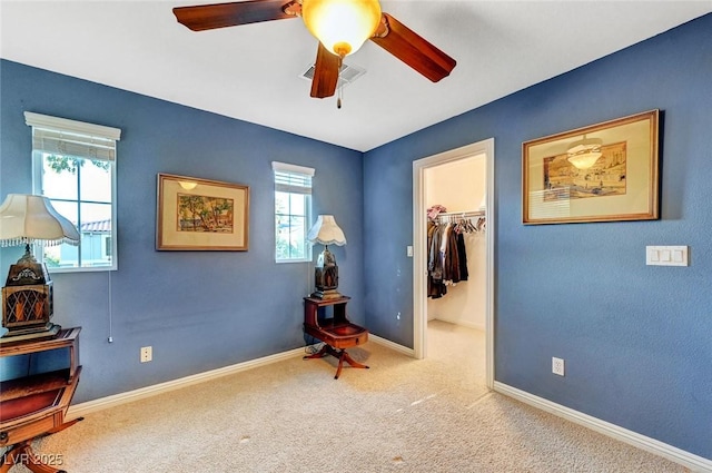 bedroom with carpet floors, a closet, baseboards, a walk in closet, and ceiling fan