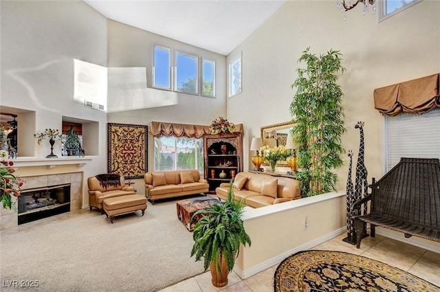 tiled living room featuring visible vents, baseboards, a towering ceiling, and a fireplace