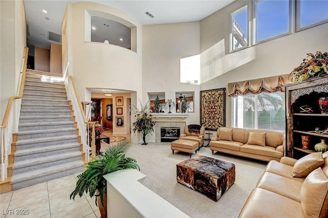 1353 Volturno Way, Henderson, NV 89052 - tiled living room featuring a high ceiling, stairway, a tile fireplace, and recessed lighting