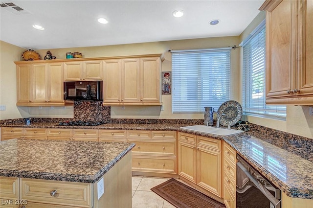 kitchen featuring visible vents, light brown cabinets, a sink, light tile patterned floors, and black appliances