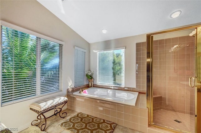 full bath featuring a bath, vaulted ceiling, a healthy amount of sunlight, and tile patterned flooring