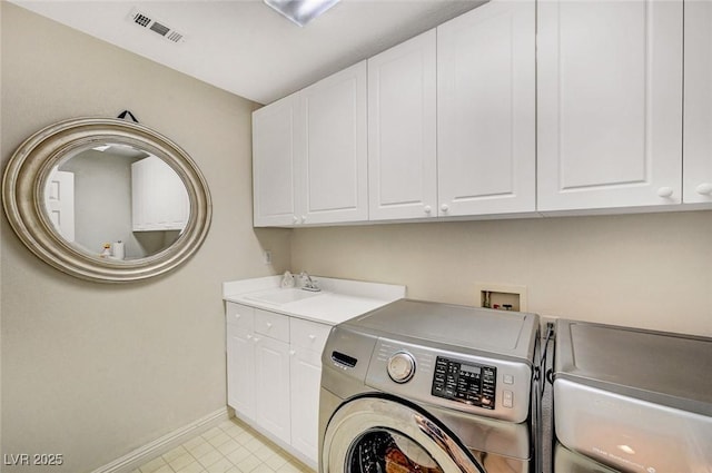 clothes washing area featuring visible vents, baseboards, washer and clothes dryer, a sink, and cabinet space