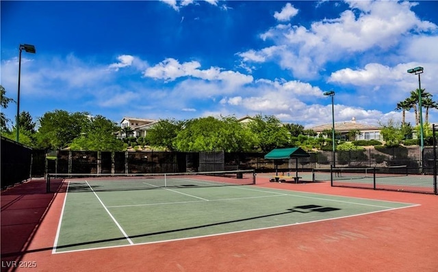 view of tennis court featuring fence and community basketball court
