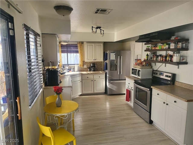 3164 Elmrock Pl, Las Vegas, NV 89121 - kitchen featuring open shelves, light wood-style flooring, stainless steel appliances, white cabinetry, and visible vents