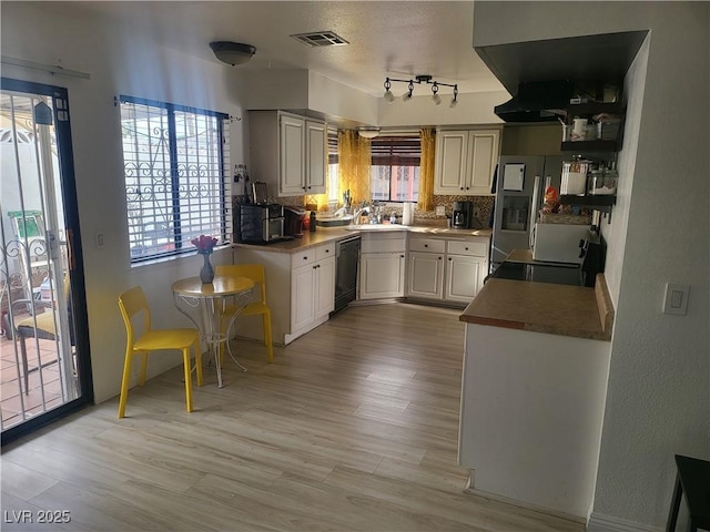 3164 Elmrock Pl, Las Vegas, NV 89121 - kitchen with backsplash, stainless steel appliances, visible vents, and light wood-style flooring