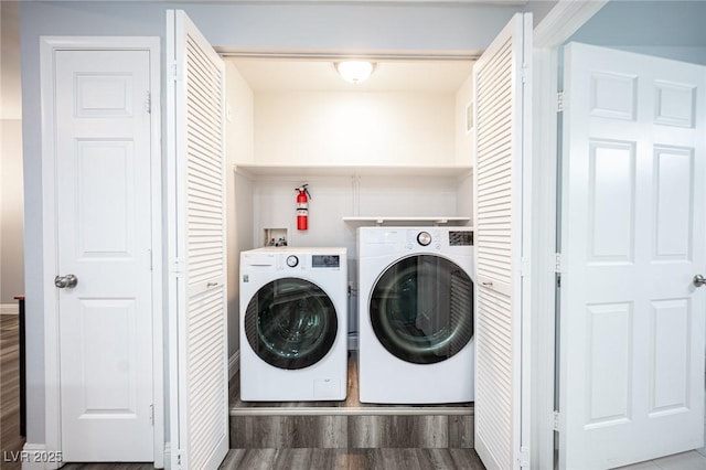 laundry room with baseboards, laundry area, washer and clothes dryer, and wood finished floors